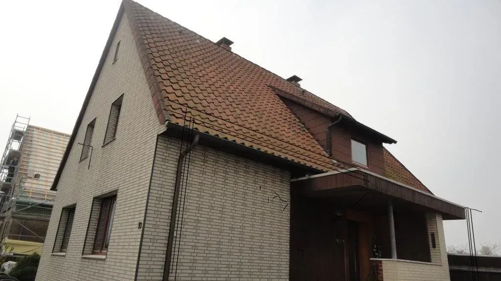 Umfassende Dachmodernisierung: Glanzziegel, präzise Schieferarbeiten und neues Vordach